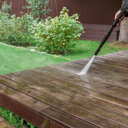 man-cleaning-walls-floor-with-high-pressure-power-washer-washing-terrace-wood-planks-cladding-walls